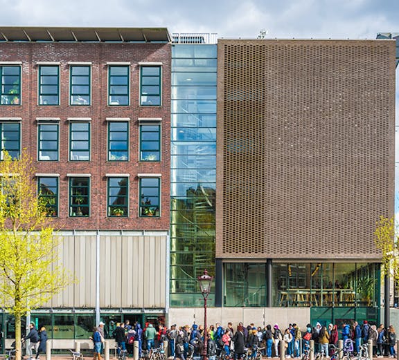 Anne Frank House in Amsterdam with visitors lined up outside.