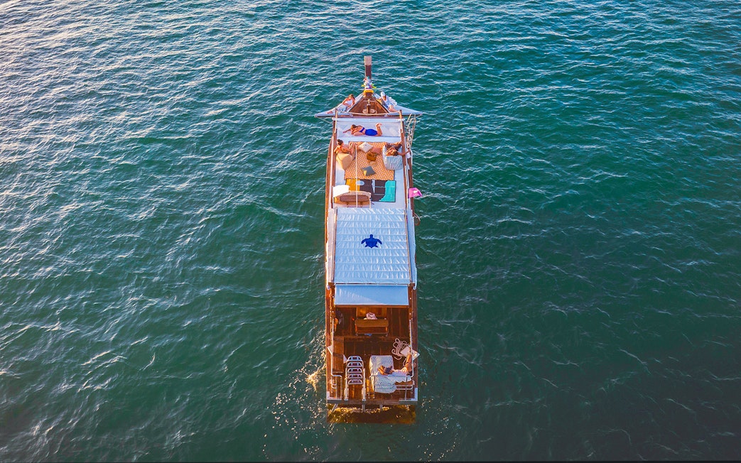 Longtail boat cruise at sunset in Krabi with people relaxing on deck.