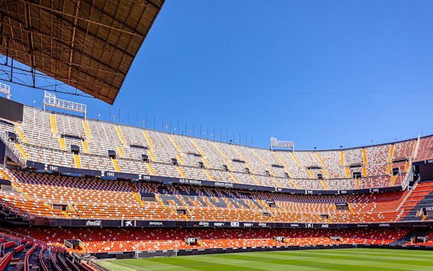 Mestalla Stadium seating and field under clear blue sky in Valencia.