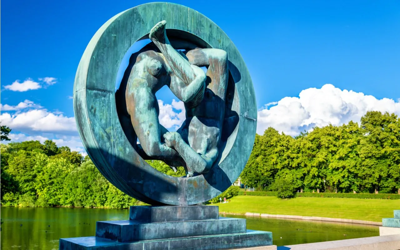 Sculpture in Vigeland Park, Oslo, depicting intertwined figures against a lush park backdrop.