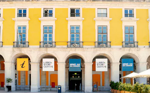 Lisboa Story Centre entrance with yellow facade and informational signs.
