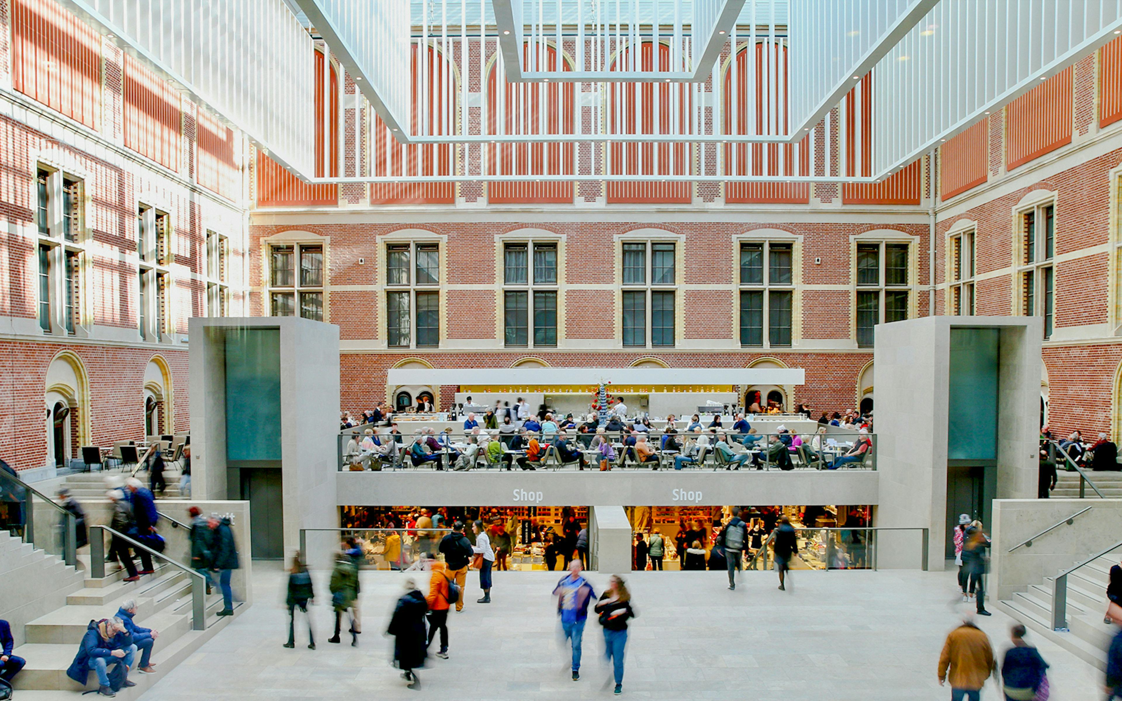 Rijksmuseum main hall with visitors and shops in Amsterdam.