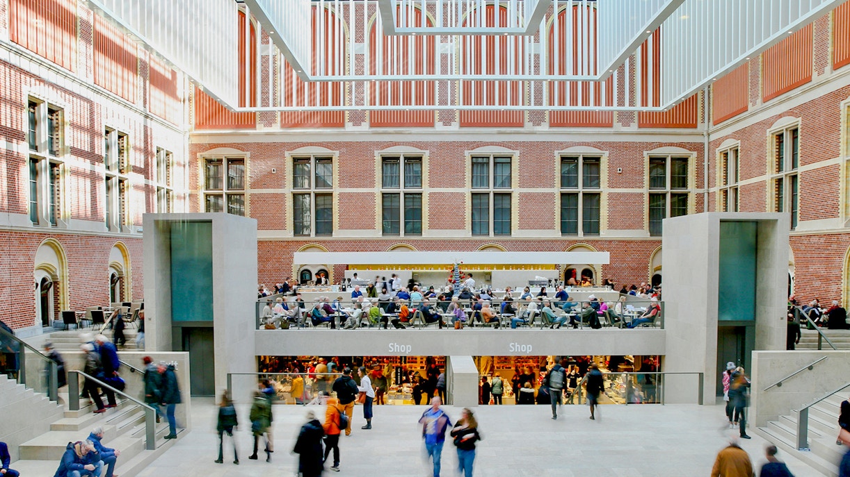 Rijksmuseum main hall with visitors and shops in Amsterdam.