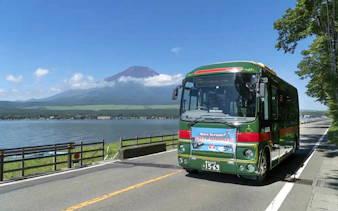 Bus near Lake Yamanaka with Mount Fuji in background, Japan.
