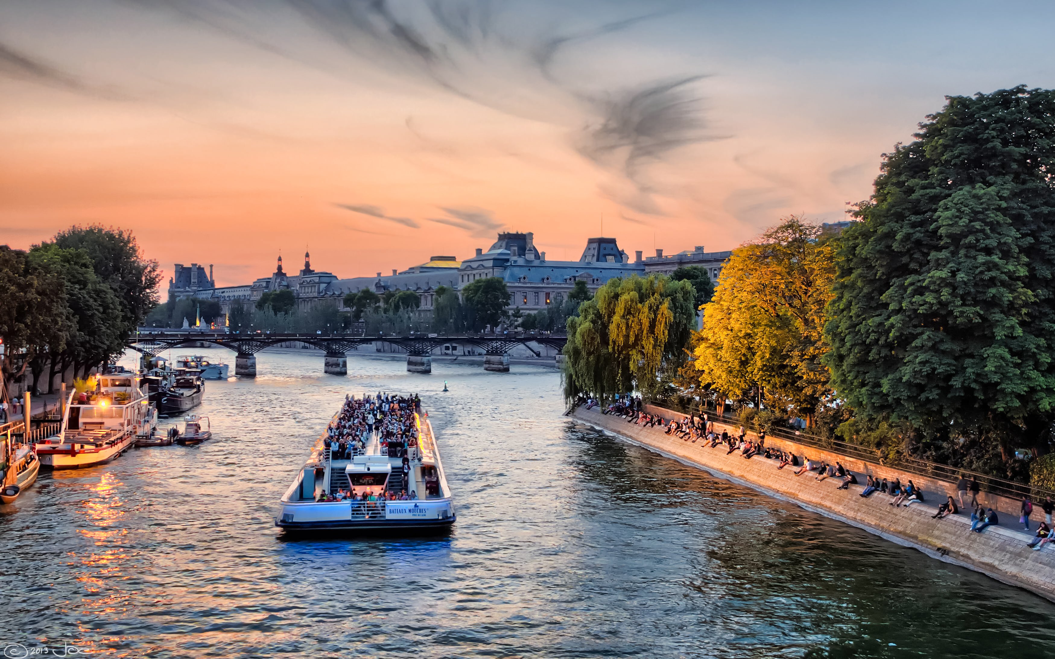 Evening cruise on the Seine River with sunset view and Parisian landmarks.
