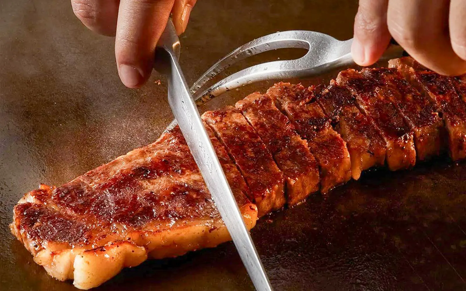 Slicing grilled steak on Okura Cruise Bangkok.