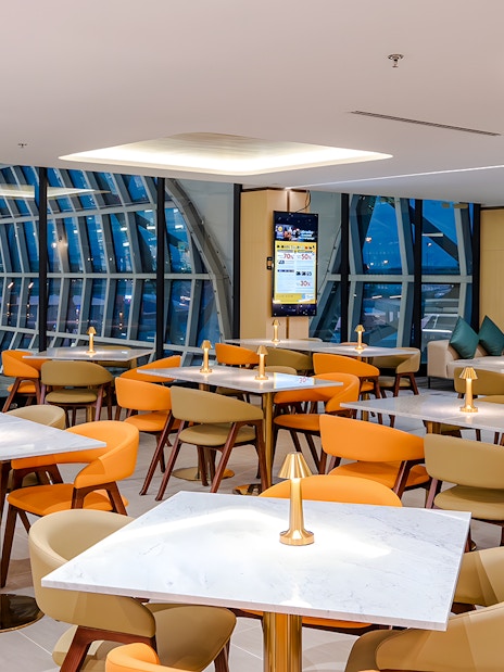 Coral Cosmo Lounge seating area with tables and chairs, Concourse C, Bangkok airport, Thailand.