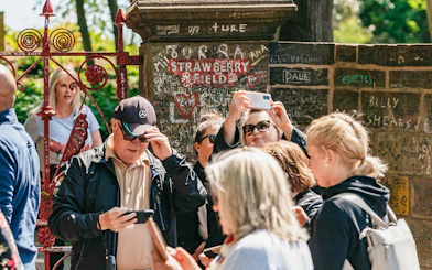 Tourists photographing Strawberry Field gate in Liverpool.