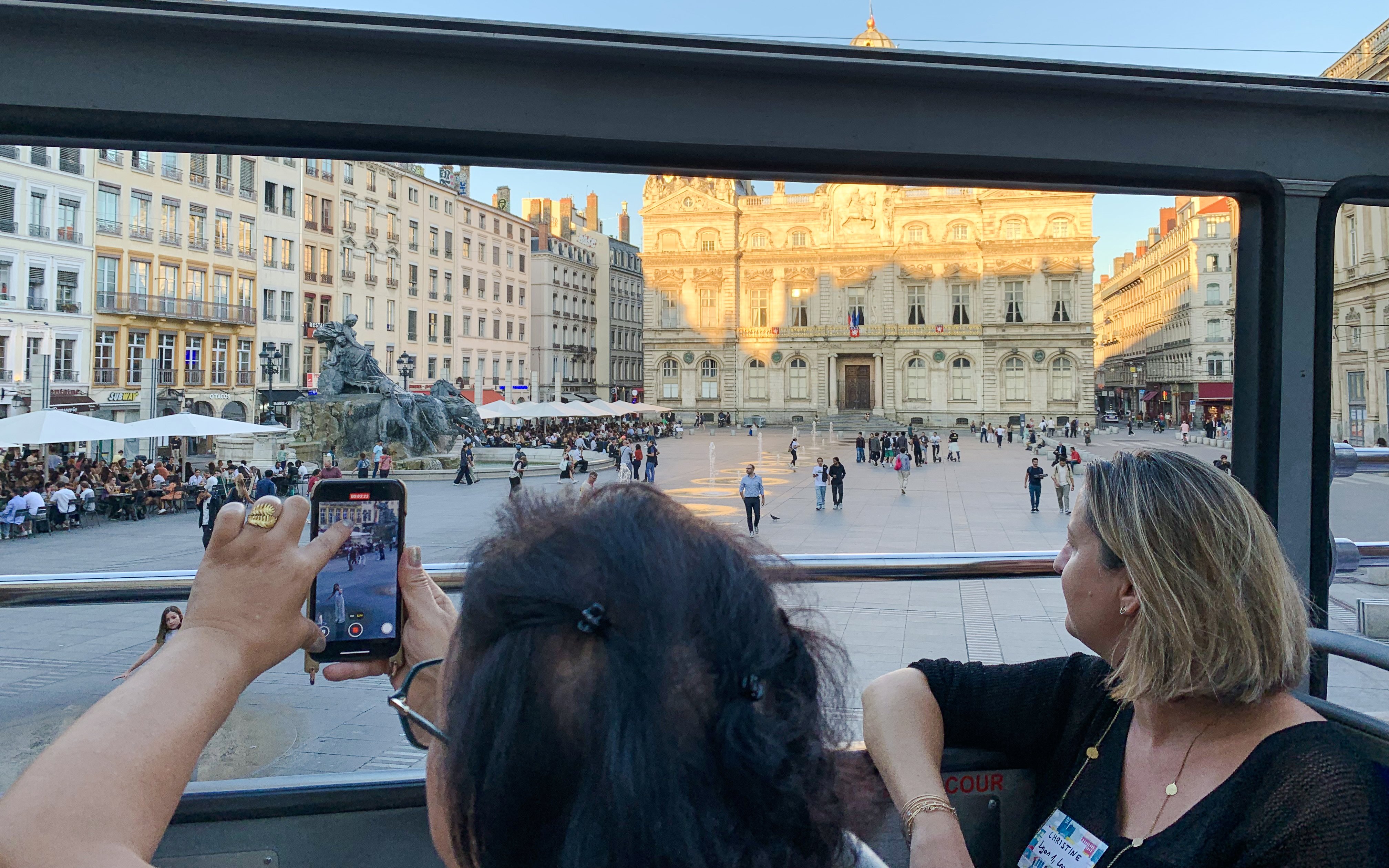 Open-top bus view of Lyon's Place des Terreaux and Bartholdi Fountain, France.
