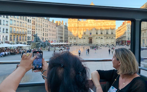 Open-top bus view of Lyon's Place des Terreaux and Bartholdi Fountain, France.