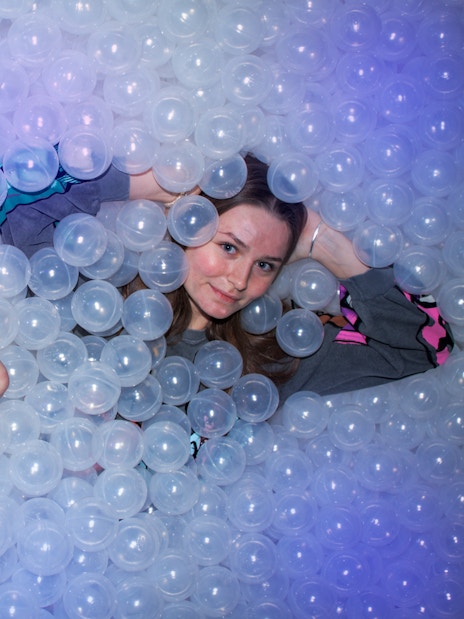 People lying in a ball pit at The TUBE attraction.