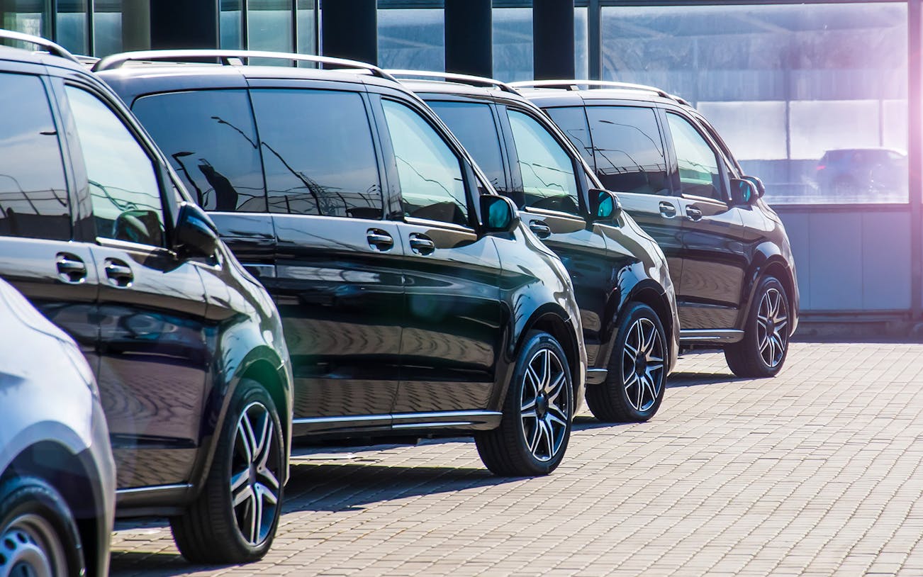 Row of black luxury vans for Tokyo airport private transfer.