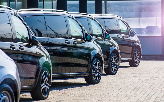 Row of black luxury vans for Tokyo airport private transfer.