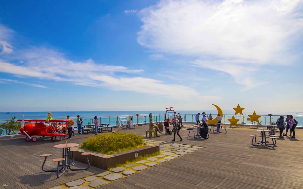 Visitors enjoying the Songdo Marine Cable Car observation deck in Busan, overlooking the ocean.