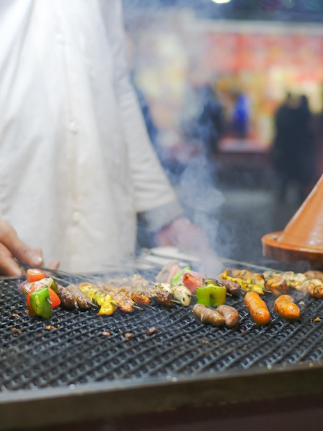 Grilled skewers and tagine at Jema el Fna street food stall in Marrakesh.