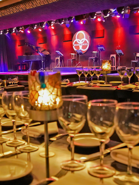 Dining setup at Michelangelo Tango Show with stage and lighting in Buenos Aires.