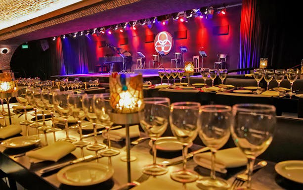 Dining setup at Michelangelo Tango Show with stage and lighting in Buenos Aires.