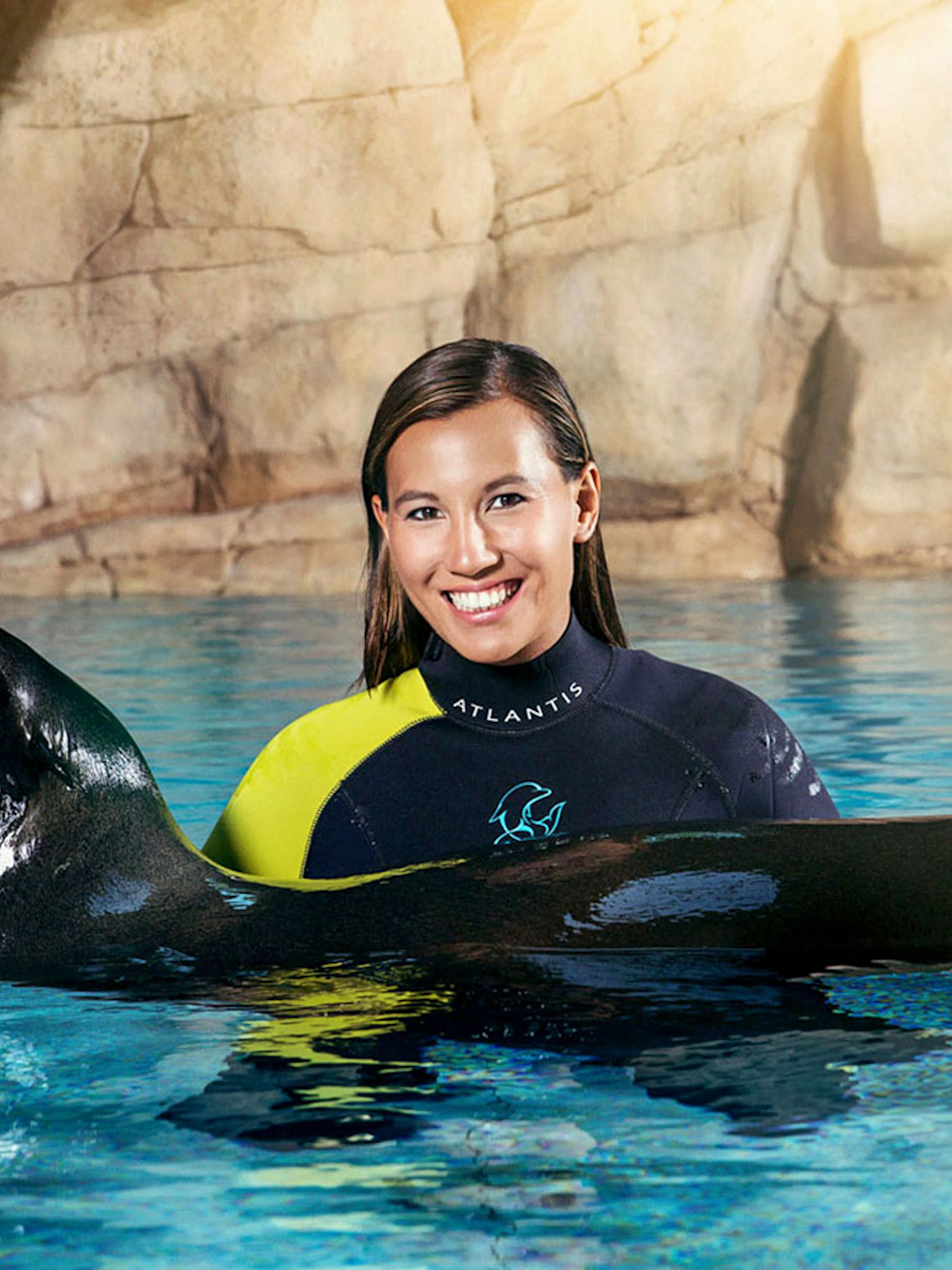 Sea lion encounter at Aquaventure Waterpark, person in wetsuit smiling in pool.