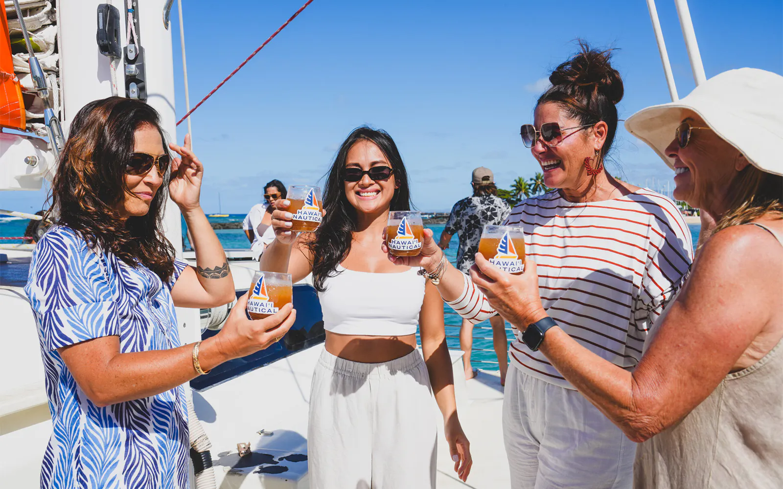 Group enjoying drinks on a Kaula Kai Sunset Sail in Oahu.