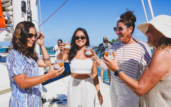 Group enjoying drinks on a Kaula Kai Sunset Sail in Oahu.