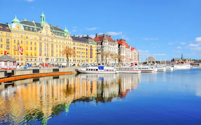 Canal cruise boats docked along Strandvagen embankment, Djurgrden City.
