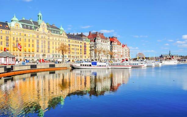 Canal cruise boats docked along Strandvagen embankment, Djurgrden City.