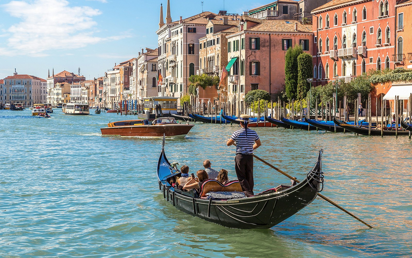 Gondola on Venice's Grand Canal with historic buildings in the background.