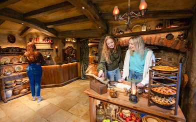 Girls exploring inside a hobbit house kitchen, Hobbiton Movie Set tour.