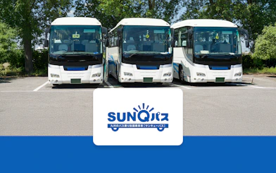Tour buses parked in Japan with SunQ Pass logo.