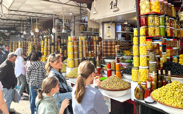 Market stall with jars of olives and preserved goods in Marrakech Medina.