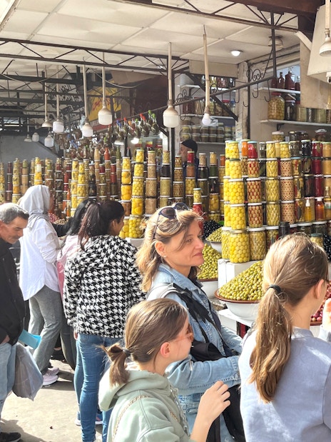 Market stall with jars of olives and preserved goods in Marrakech Medina.