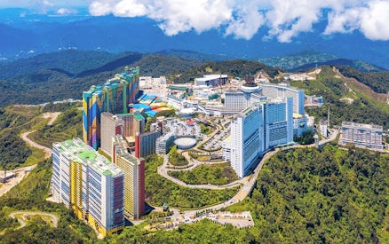 Aerial view of Genting Highlands resort complex surrounded by lush green hills.