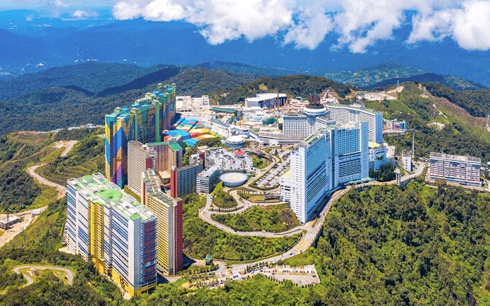 Aerial view of Genting Highlands resort complex surrounded by lush green hills.