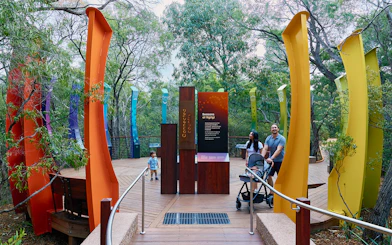 Ngilgi Cave entrance with colorful pillars and visitors exploring the Ancient Lands Experience.
