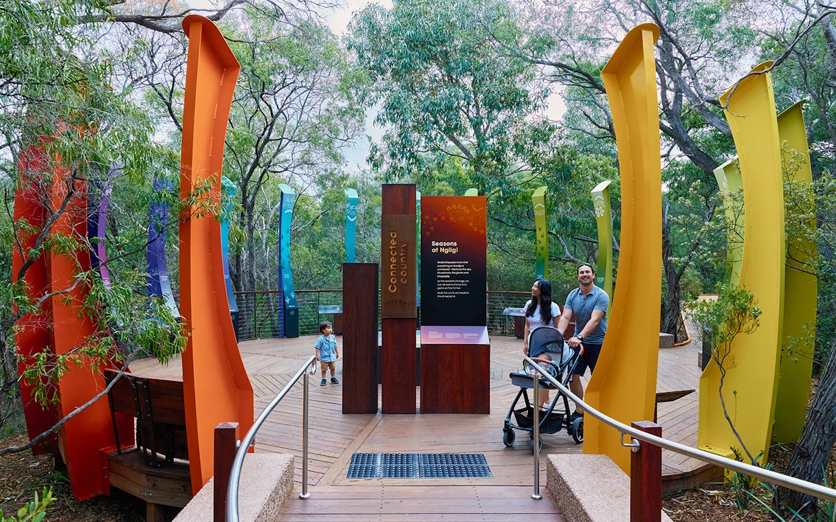 Ngilgi Cave entrance with colorful pillars and visitors exploring the Ancient Lands Experience.