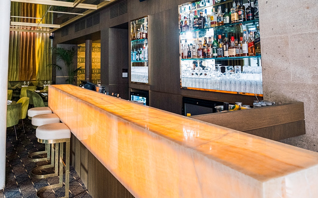 Bar area at Crazy Horse Paris with illuminated counter and stocked shelves.