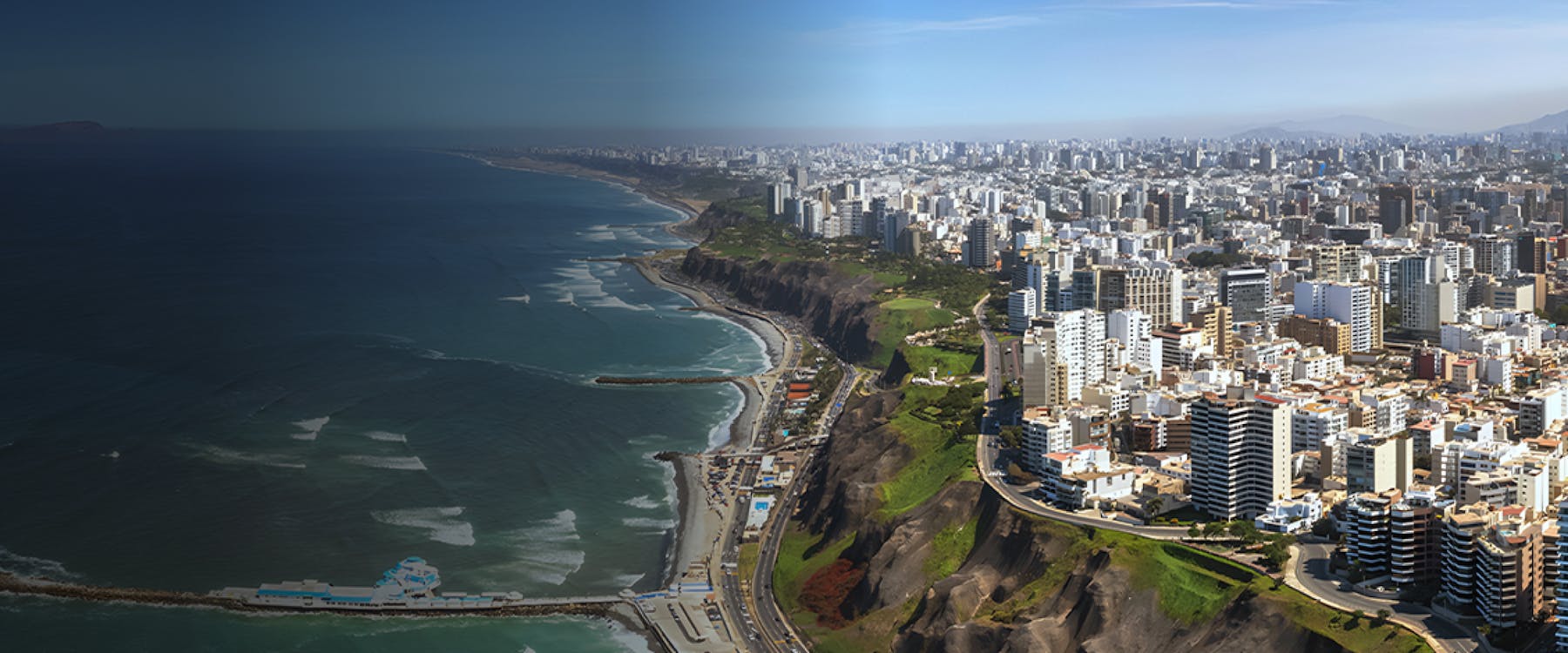 Aerial view of Lima's coastline with cityscape and cliffs, Peru.