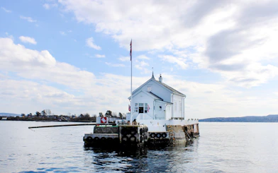 White house on a small island in Oslofjord during sightseeing cruise.