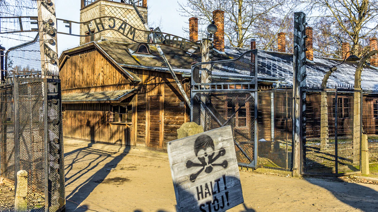 Auschwitz-Birkenau entrance gate with warning sign, part of guided tour from Krakow.