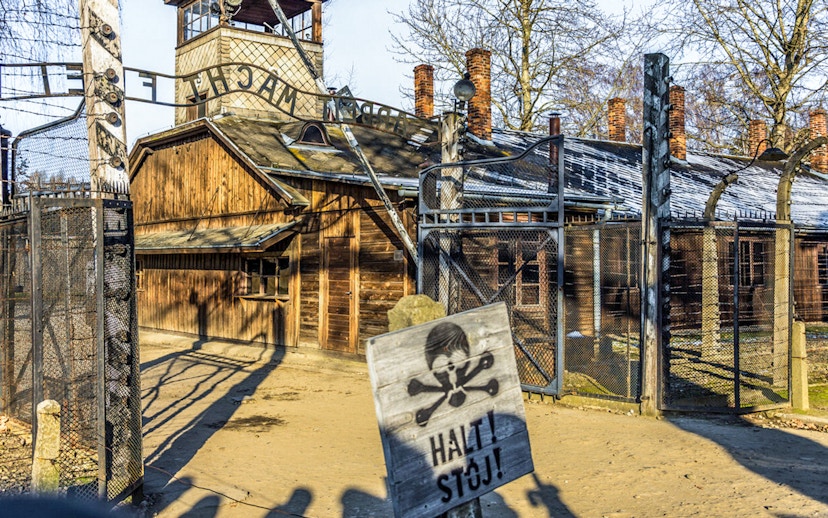 Auschwitz-Birkenau entrance gate with warning sign, part of guided tour from Krakow.