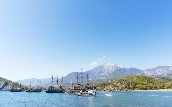 Boats anchored near Phaselis with mountains in the background, Antalya tour.