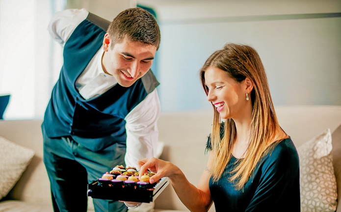 Server presenting cupcakes to a woman at Burj Khalifa cafe.