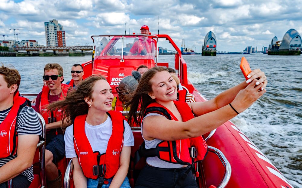 Speedboat cruise on the Thames River with passengers enjoying the view in London.