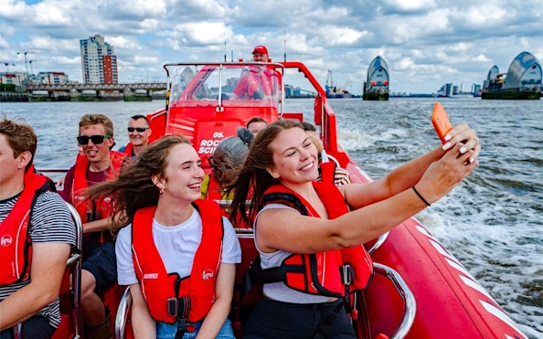 Speedboat cruise on the Thames River with passengers enjoying the view in London.