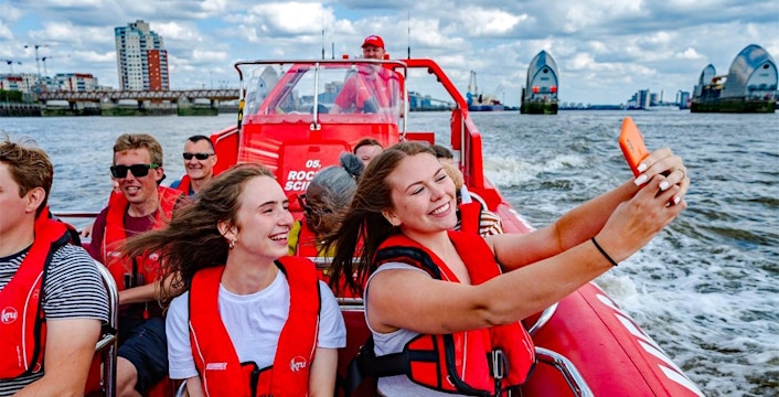 Speedboat cruise on the Thames River with passengers enjoying the view in London.