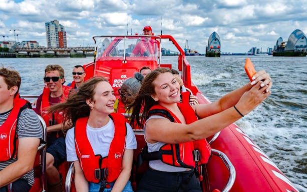 Speedboat cruise on the Thames River with passengers enjoying the view in London.
