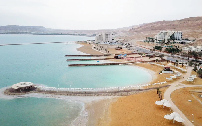 Aerial view of the Dead Sea coastline with hotels and beach umbrellas, Israel.
