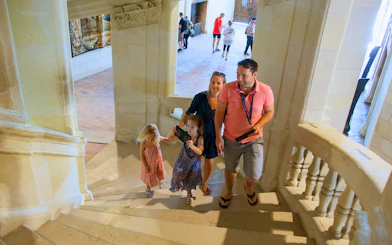 Family ascending stairs in Chambord Castle, France.