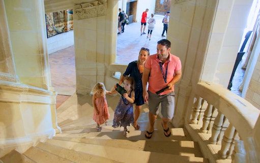 Family ascending stairs in Chambord Castle, France.
