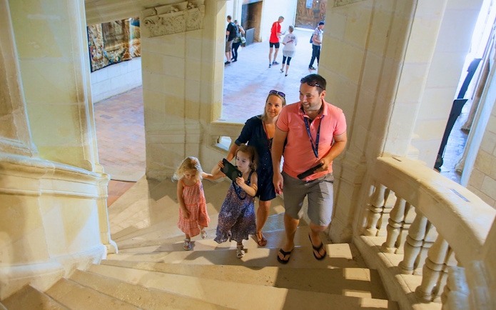 Family ascending stairs in Chambord Castle, France.